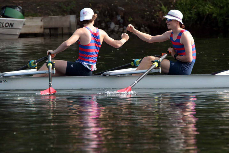 Two Junior Men fist pumping in a 2x.
